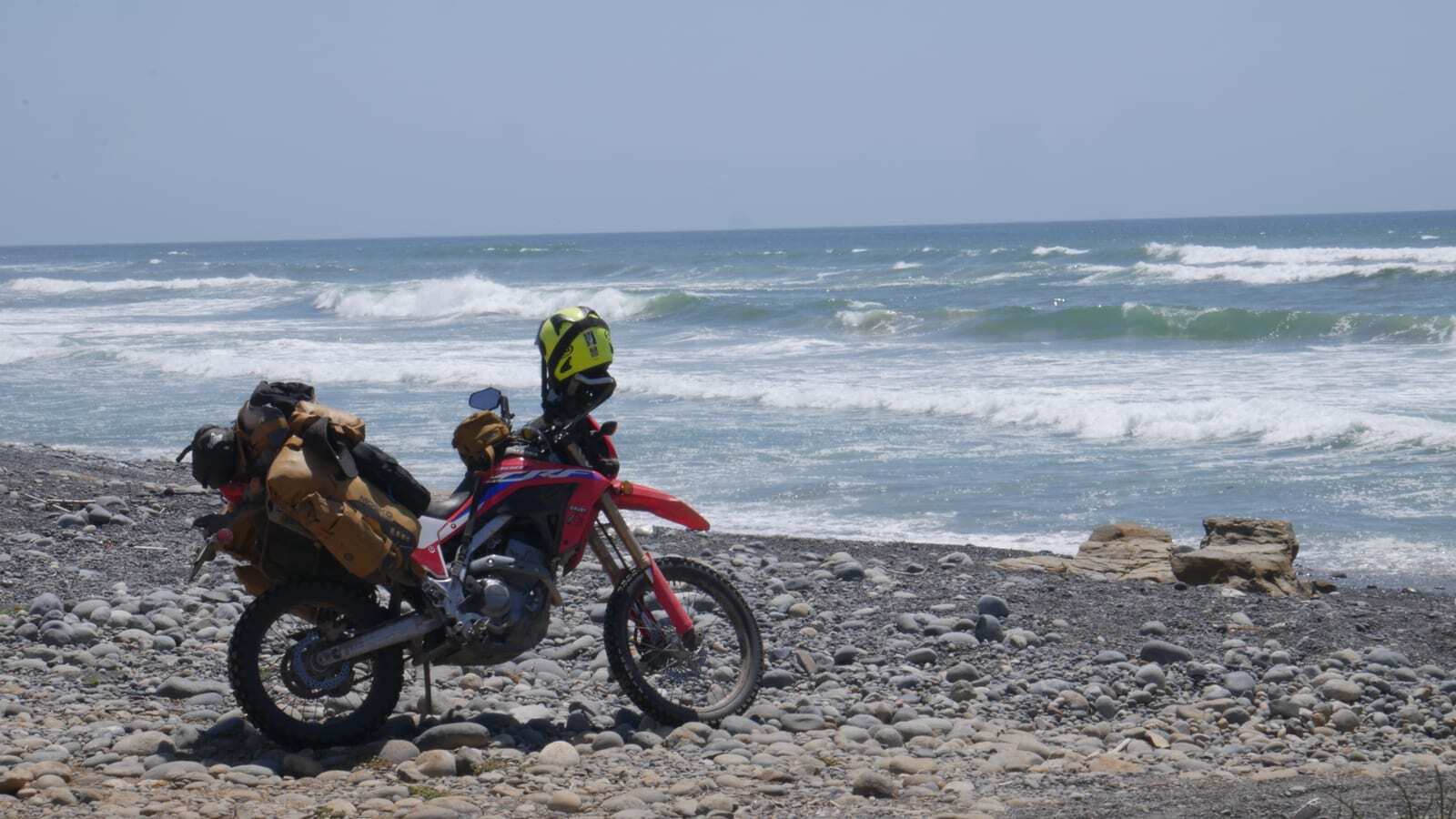 A motorcycle parked on a rocky beach in Baja, Mexico