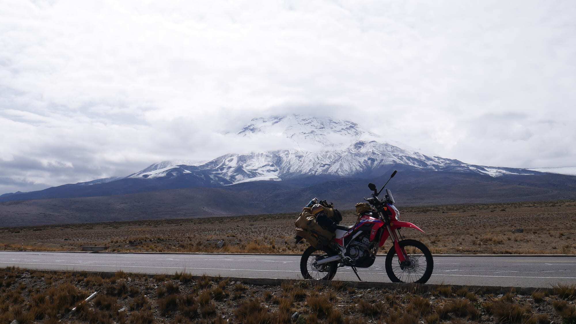 My loaded motorcycle beneath snow-covered Chimborazo